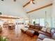 Open floor plan with high ceilings, exposed beams, hardwood floors and large leather sectional in living room at 27 Fitzroy Dr, Charleston, SC 29414