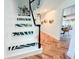 Bright stairway with tropical leaf decals, black banister, and herringbone wood floors at 27 Fitzroy Dr, Charleston, SC 29414