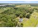 Aerial view showcasing a beautiful home surrounded by trees, green lawns, and a river at 2962 Anchor Watch Dr, Wadmalaw Island, SC 29487