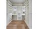 Bright walk-in closet with custom shelves and drawers and beautiful hardwood floors at 2962 Anchor Watch Dr, Wadmalaw Island, SC 29487