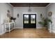 Elegant entryway with a wood-paneled ceiling, black double doors, and stylish decor creates a welcoming ambiance at 2962 Anchor Watch Dr, Wadmalaw Island, SC 29487
