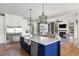 Open-concept kitchen with a large island, stainless steel appliances, and seamless flow to the living room with fireplace at 2962 Anchor Watch Dr, Wadmalaw Island, SC 29487