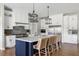 Stylish kitchen boasts a center island with seating, white cabinets, modern appliances, and elegant pendant lighting at 2962 Anchor Watch Dr, Wadmalaw Island, SC 29487