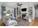 Bright living room with fireplace, flat-screen TV, fan, stylish furniture and hardwood floors at 2962 Anchor Watch Dr, Wadmalaw Island, SC 29487