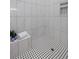 Modern bathroom with tile shower featuring black and white tile floors and built-in shelf at 2962 Anchor Watch Dr, Wadmalaw Island, SC 29487