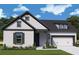 Charming one-story home with white siding, black trim, and a two-car garage in a suburban neighborhood at 326 Trailmore Ln, Summerville, SC 29486