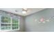 Bright bedroom with light gray paint, floral decals, a ceiling fan, and a large window at 402 Pine Bluff Dr, Summerville, SC 29483