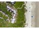 Bird's eye view showing beachfront condos, lush greenery, and sandy beach with a boardwalk access at 4303 Sea Forest Dr, Kiawah Island, SC 29455