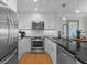 Modern kitchen with stainless steel appliances, white cabinets, and hardwood floors at 4303 Sea Forest Dr, Kiawah Island, SC 29455