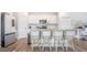 Bright, white kitchen features stainless appliances, a granite-topped island, and stylish bar stool seating at 452 Minim St, Charleston, SC 29414