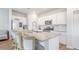 Bright, white kitchen features stainless appliances, a granite-topped island, and stylish bar stool seating at 452 Minim St, Charleston, SC 29414