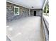 Covered patio with gray brick exterior and gray flooring, offers a view of the yard at 4649 N U.S. Highway 52, Saint Stephen, SC 29479