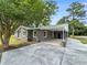 View of home with brick exterior, white trim, and covered parking area; concrete driveway and landscaping at 4649 N U.S. Highway 52, Saint Stephen, SC 29479