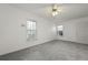 A well-lit bedroom with two windows, a ceiling fan, light walls, and plush carpeting at 4735 W Park Pl, North Charleston, SC 29405