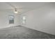 A bright bedroom is naturally illuminated by two windows with neutral colored walls and plush carpeting at 4735 W Park Pl, North Charleston, SC 29405