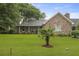 Charming brick home with a well-manicured lawn, mature trees, and a cozy front porch at 4735 W Park Pl, North Charleston, SC 29405