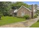 Beautiful brick home with lush green lawn and mature trees along the driveway at 4735 W Park Pl, North Charleston, SC 29405