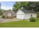 White detached two-car garage with black roof, adjacent to the brick home and driveway at 4735 W Park Pl, North Charleston, SC 29405