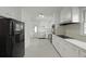 Traditional kitchen with white cabinetry and gray tile floors, plus modern black appliances at 4735 W Park Pl, North Charleston, SC 29405