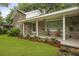 Inviting front porch with brick columns and seating overlooking the landscaped lawn at 4735 W Park Pl, North Charleston, SC 29405