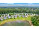 Expansive aerial view of a lakeside community featuring well-manicured lawns and lush green trees, showcasing a serene neighborhood setting at 4831 Carnoustie Ct, Summerville, SC 29485