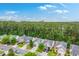 An aerial shot displays rows of homes with manicured lawns and driveways, complemented by the dense greenery of the trees at 4831 Carnoustie Ct, Summerville, SC 29485