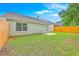 A fenced backyard features a well-maintained lawn and a small concrete patio near the back door at 4831 Carnoustie Ct, Summerville, SC 29485