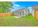 A fully fenced backyard features green grass, a small patio, and a well-maintained lawn at 4831 Carnoustie Ct, Summerville, SC 29485