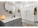 Updated bathroom featuring a shower over bath, modern vanity, and elegant round mirror at 557 Blueway Ave, Summerville, SC 29486