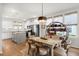 Open concept dining area with modern chandelier flowing into the kitchen with island at 557 Blueway Ave, Summerville, SC 29486