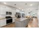 Open kitchen featuring white cabinets, granite countertops, and a spacious island with stainless steel appliances at 557 Blueway Ave, Summerville, SC 29486