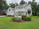 Two-story house featuring a manicured lawn, vibrant greenery, and a charming white picket fence at 605 Pointe Of Oaks Rd, Summerville, SC 29485