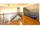 Bright hallway with hardwood floors and wood railing leading to the stairs at 6212 Fieldstone Cir, Charleston, SC 29414