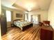 Spacious bedroom featuring a decorative bed frame, ensuite doors, and hardwood floors at 6212 Fieldstone Cir, Charleston, SC 29414