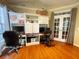 Spacious office area with built-in shelving, dual workstations, and french doors at 6212 Fieldstone Cir, Charleston, SC 29414