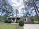 Beautiful brick home surrounded by lush green landscaping and towering mature trees at 710 Gadsden Loop, Walterboro, SC 29488