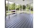 Spacious screened porch with gray wood flooring and built-in bench seating at 710 Gadsden Loop, Walterboro, SC 29488