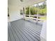 Relaxing screened porch boasts white columns, a built-in bench, and a grey wood floor for comfortable outdoor living at 710 Gadsden Loop, Walterboro, SC 29488