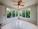 Bright sunroom with tile floors, ceiling fan, and multiple windows showcasing the backyard at 710 Gadsden Loop, Walterboro, SC 29488