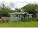 Charming home with a green exterior, a cozy front porch, and a well-maintained lawn at 716 White Oak Dr, Charleston, SC 29407