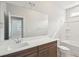 Bathroom featuring a dark wood vanity with a white countertop, tub, and large mirror at 735 Breakers Reef Ln, Huger, SC 29450