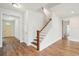 Hallway with hardwood flooring, white trim, and access to various rooms in the home at 735 Breakers Reef Ln, Huger, SC 29450