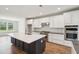 Modern kitchen with white cabinets, stainless steel appliances, and a center island with a sink at 735 Breakers Reef Ln, Huger, SC 29450