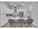 Modern white kitchen with stainless steel appliances, pendant lights, and counter seating at 7413 Indigo Palms Way, Johns Island, SC 29455