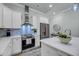 Bright kitchen featuring white cabinets, stainless steel appliances, and marble backsplash at 7432 Indigo Palms Way, Johns Island, SC 29455