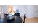 Dining area showcasing black table, white walls, hardwood floors, and a view into the bright kitchen at 760 Natchez Circle Cir, Mount Pleasant, SC 29464