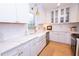 Beautiful kitchen featuring white cabinets, gold hardware, farmhouse sink, and elegant marble countertops at 760 Natchez Circle Cir, Mount Pleasant, SC 29464