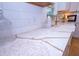 Detailed view of marble countertop with gold accents, farmhouse sink, white backsplash and cabinetry at 760 Natchez Circle Cir, Mount Pleasant, SC 29464