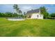 Expansive backyard featuring a pool and a well-maintained lawn with mature trees at 810 Highway 61, Ridgeville, SC 29472
