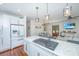 Open-concept kitchen with white cabinets and modern gas cooktop island at 810 Highway 61, Ridgeville, SC 29472